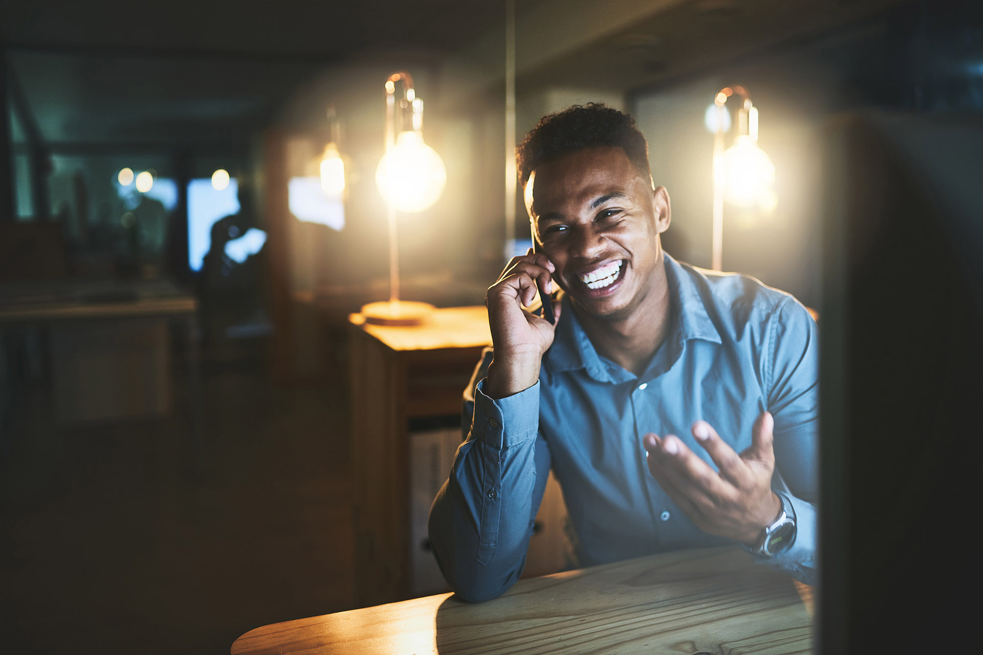 Night, smile and businessman at desk with phone call, connection and lead generation at tech startup. Dark, office and happy black man with smartphone, networking and communication at digital agency.